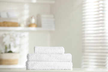 Fototapeta na wymiar Stack of clean soft towels on white table indoors