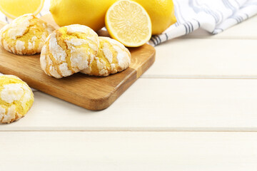 Tasty homemade lemon cookies and fresh fruits on white wooden table. Space for text