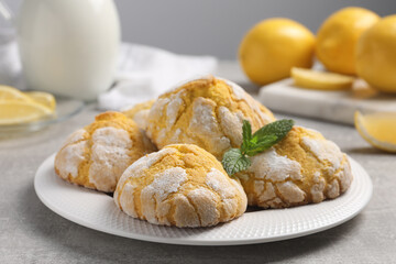 Plate with delicious lemon cookies and mint on grey table, closeup