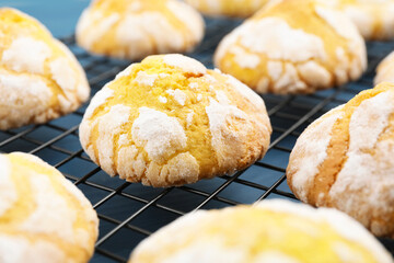 Tasty homemade lemon cookies on cooling rack, closeup