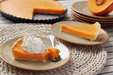 Fresh homemade pumpkin pie with whipped cream on table