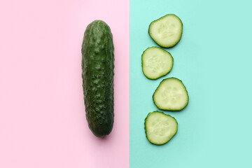 Whole and cut cucumbers on color background, flat lay