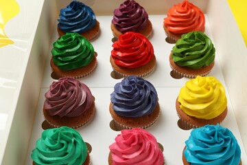 Different cupcakes with cream in box, closeup