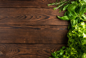 greens and vegetables on a wooden background