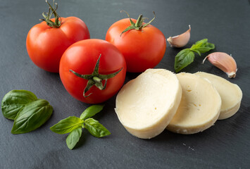 tomato basil mozzarella garlic on a dark background