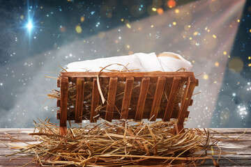 Wooden manger with baby on wooden table at night. Concept of Christmas story