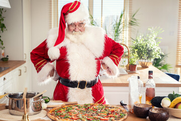 Real Santa Claus making italian delicious pizza at home in kitchen. Christmas .