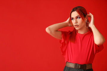 Stylish transgender woman on red background