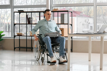 Young man with physical disability working in office