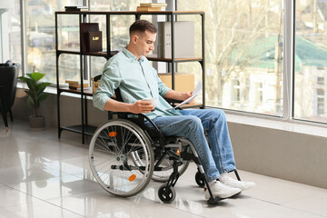 Young man with physical disability working in office