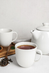 Composition with hot black tea on white table