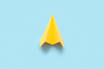 Yellow paper plane on blue background