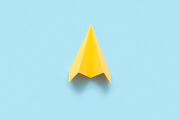 Fototapeta premium Yellow paper plane on blue background