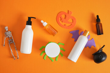creative composition of cosmetic bottles and halloween decor