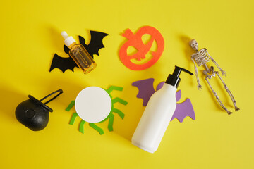creative composition of cosmetic bottles and halloween decor