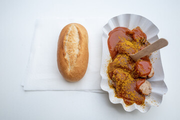 Top view of Currywurst, grilled pork sausage on top with curry powder served with curry ketchup...