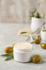 Fototapeta na wymiar Jar of natural olive cream on light table