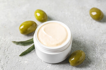 Fototapeta na wymiar Jar of natural olive cream on light background