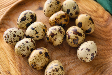 Obraz premium Wooden plate with fresh quail eggs, closeup