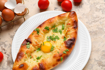 Plate of tasty Ajarian khachapuri on table, closeup