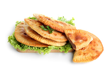 Board with tasty chebureks, parsley and lettuce on white background