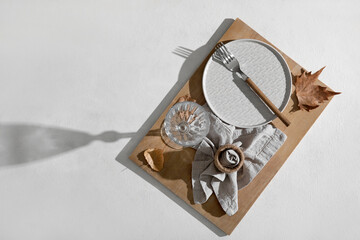 Beautiful autumn table setting with fallen leaves on white background