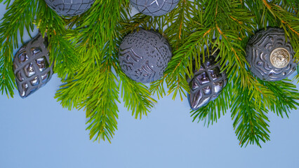 Fototapeta na wymiar christmas mockup with gray balls and Christmas tree branches on a gray background.copy space.Christmas balls background.Festive mockup in gray tones in a minimalistic style and monochrome color. 