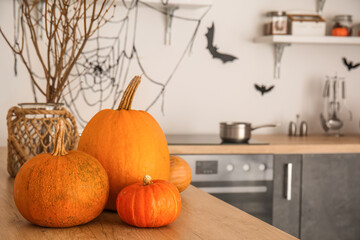 Fresh pumpkins on counter in kitchen decorated for Halloween, closeup
