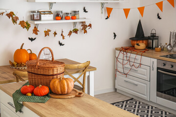 Basket with Halloween pumpkins on counter in kitchen