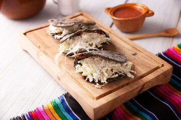 Gordita de Chicharron. Blue Cornmeal dough stuffed with chicharron prensado. Traditional Mexican appetizer commonly accompanied by cilantro, onion and hot sauce.