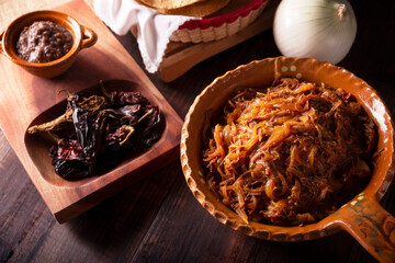 Tinga de Res. Typical Mexican dish prepared mainly with shredded beef, onion and dried chilies. It...