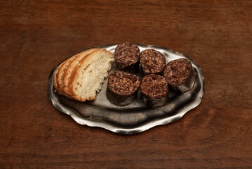 Typical hard and insane Spanish tapa of fried rice blood sausage with sliced village bread