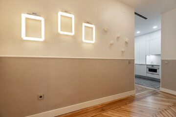 Hallway of a vacation rental home with beautiful pine wood flooring and light design frames