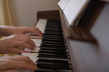 Obraz premium Two people playing the piece for piano duet in the room. 部屋のピアノで連弾する二人