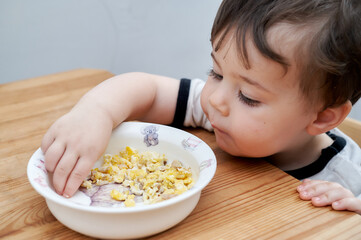 toddler eating eggs for breakfast and fooling around