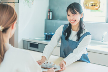 笑顔で食事を提供する女性　Kitchen