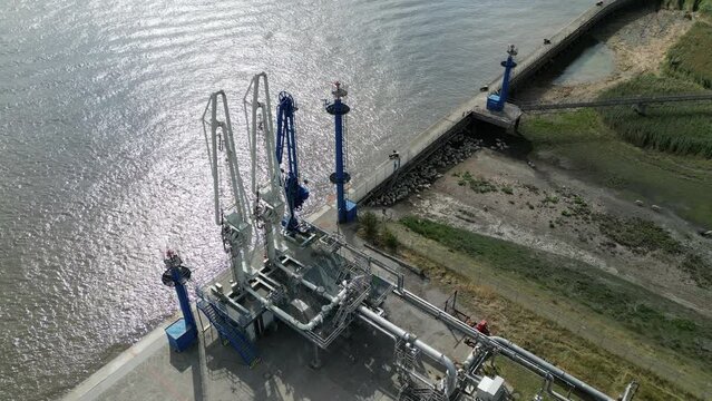 Aerial view of a gas and oil unloading terminal with pipeline and cranes, future site of an LNG terminal
