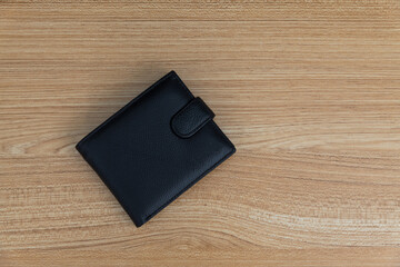 Black leather wallet on wooden table