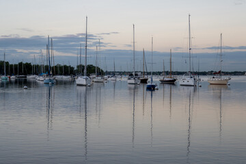 Sailboats in Dinner Key anchorage reflected in calm water of Biscayne Bay in Miami, Florida.