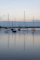 Fototapeta na wymiar Sailboats in Dinner Key anchorage reflected in calm water of Biscayne Bay in Miami, Florida.