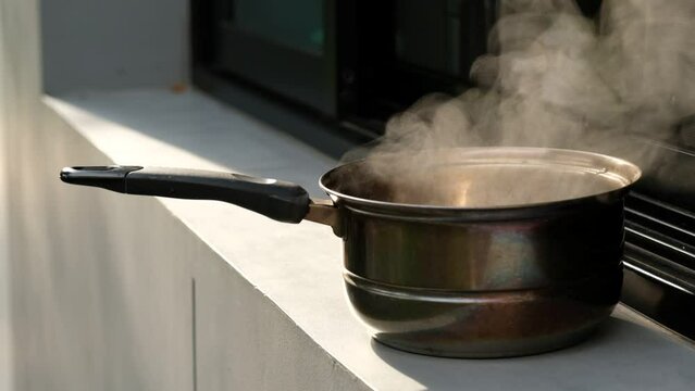 the water is boiling in the pot, hot water
