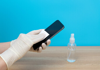 Woman hand cleaning mobile phone with napkin