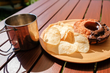 キャンプで食べるチョコオールドファッションドーナツとポテトチップス