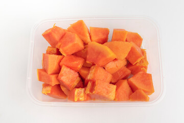 close up of fresh orange papaya on plastic box isolated on white background