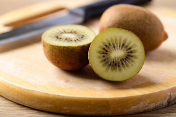 Fresh golden kiwi fruit on cutting wooden board