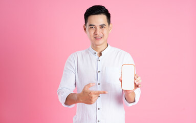 portrait of asian man posing on pink background