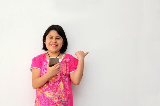 10-year-old Hispanic girl uses her cell phone to make video calls, play video games, send messages, take photos, selfies, watch and record videos as an influencer and have fun in her free time