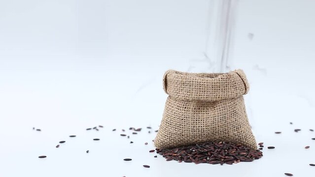 dropping rice berry in sack bag on white