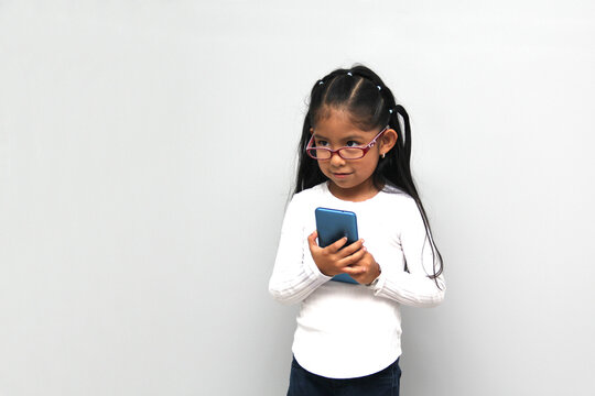 4-year-old latin girl uses her cell phone to make video calls, play video games, send messages, take photos, selfies, watch and record videos as an influencer and have fun in her free time
