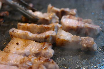 Grilling pork belly on an iron plate